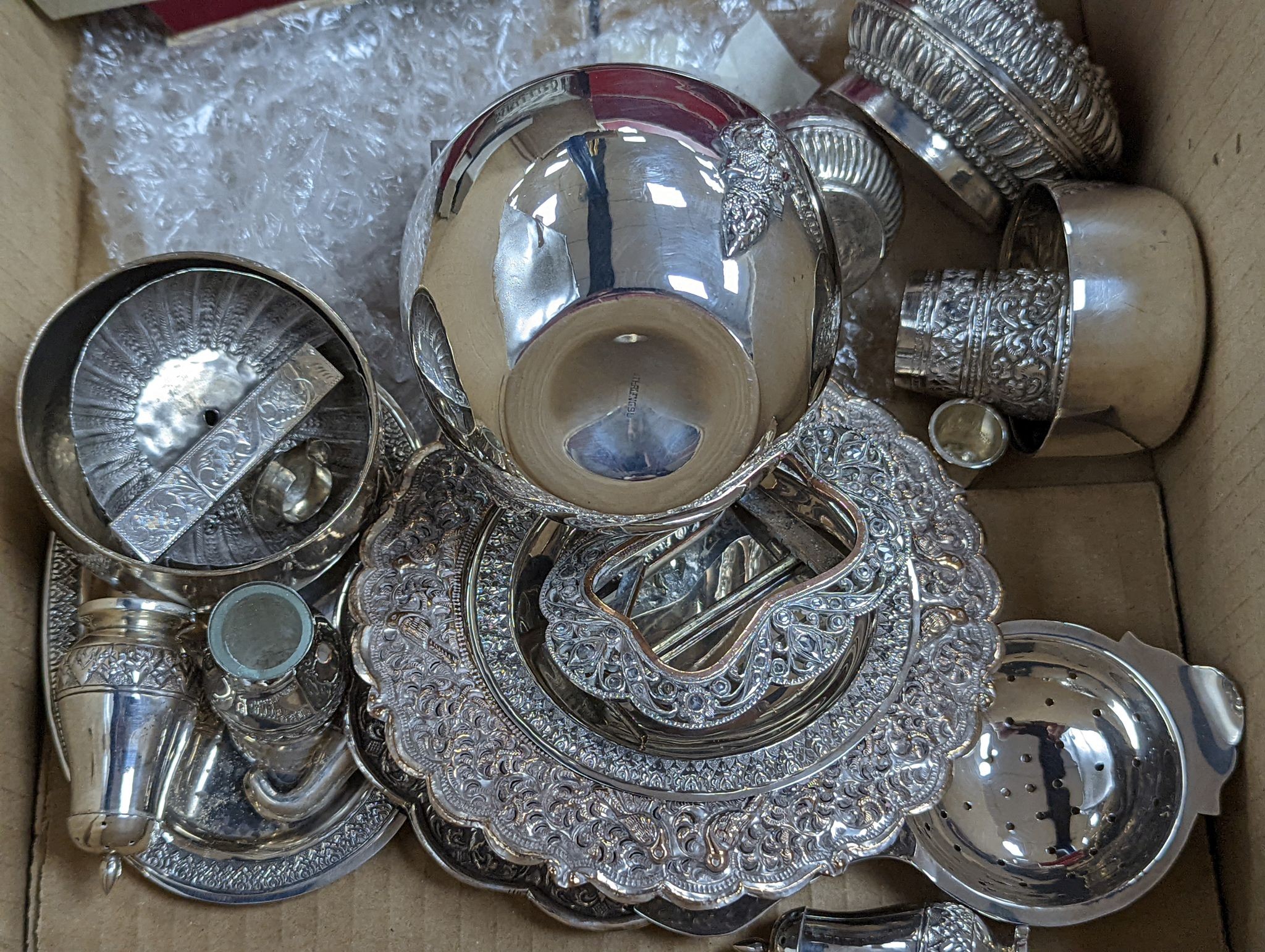 A collection of assorted white metal items including Thai boxes, Burmese figures of dancers, dishes, candlesticks, tea strainer etc. and a quantity of assorted boxed flatware.